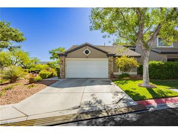 Charming single-story home featuring a well-maintained lawn, two-car garage, and desert landscaping at 504 Painted Cloud Pl, Las Vegas, NV 89144