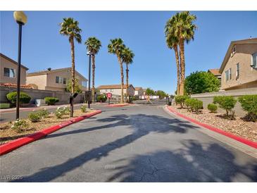 View of the community entrance with palm trees and well-maintained landscaping on a sunny day at 6420 Extreme Shear Ave # 102, Henderson, NV 89011