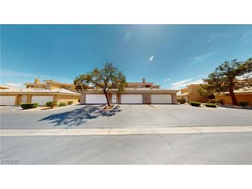 Charming townhomes featuring private garages and mature landscaping, set under a sunny sky at 6901 Cobre Azul Ave # 202, Las Vegas, NV 89108