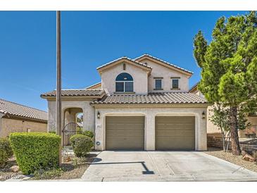 Inviting two-story home with a tile roof, lush landscaping, and a two-car garage at 841 Colina Alta Pl, Las Vegas, NV 89138