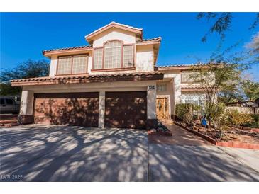 Inviting two-story home featuring a three-car garage and a well-maintained front yard at 884 E Robindale Rd, Las Vegas, NV 89123