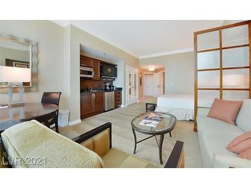 Comfortable living room with kitchenette featuring modern appliances, wooden cabinets and stylish decor at 125 E Harmon Ave # 318, Las Vegas, NV 89109