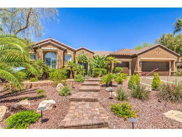 Beautiful single-story home featuring lush landscaping and a brick walkway leading to the front door at 1564 Fieldbrook St, Henderson, NV 89052
