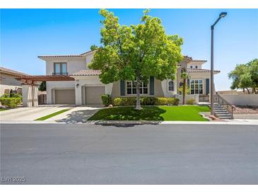 Beautiful two-story home featuring a three-car garage, manicured landscaping, and a well-maintained lawn at 220 Villa Borghese St, Las Vegas, NV 89138