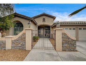 Charming stucco home featuring a gated entry, manicured landscaping, and a two-car garage at 2939 Crown Bluffs Ct, Las Vegas, NV 89117
