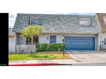 Charming two-story home with a blue front door, complementary blue garage, and a well-manicured green lawn at 3789 Heritage Ave, Las Vegas, NV 89121