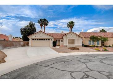 Charming single-story home features desert landscaping, a brick fire pit, and a two-car garage at 5124 Appealing Ct, Las Vegas, NV 89130