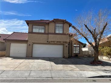 Two story home features a red tile roof, multi car garage, and a low maintenance front yard at 5255 Autumn Sky Rd, Las Vegas, NV 89118