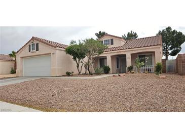 Single story home with desert landscaping, covered porch, dormer windows and a two car garage at 5900 Red Umber Ave, Las Vegas, NV 89130