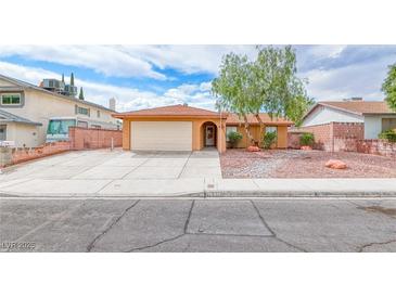Single-story home with attached garage, mature trees, and low-maintenance rock landscaping at 632 Arrayo Way, Boulder City, NV 89005