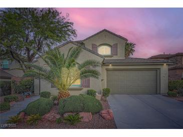 Charming two-story home featuring a well-manicured front yard with lush greenery and a spacious two-car garage at 11345 Espadrille Ct, Las Vegas, NV 89138