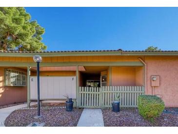 Inviting front entrance with charming light grey picket fence, peach siding and well-kept landscaping at 413 N Lamb Blvd # F, Las Vegas, NV 89110