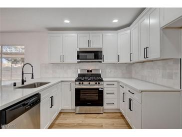 Bright kitchen features white cabinets, stainless steel appliances, and modern finishes, perfect for cooking and entertaining at 5466 Silverheart Ave, Las Vegas, NV 89142
