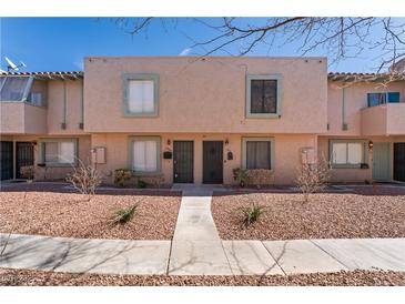 Charming townhome featuring a light peach exterior, dual black doors, and easy to maintain desert landscaping at 5939 Vegas Dr, Las Vegas, NV 89108