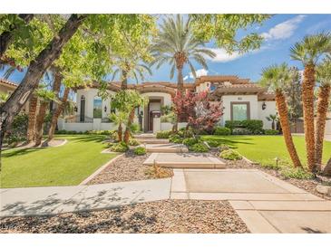 Beautiful single-Gathering home with lush lawn, mature palm trees, and a stone walkway to the front door at 764 Ricota Ct, Henderson, NV 89012