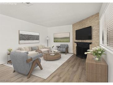 Bright living room with a decorative fireplace, modern furniture, and plenty of natural light from the large window at 829 Rock Springs Dr # 201, Las Vegas, NV 89128
