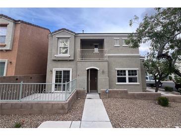 Two-story home with a front patio, balcony, and xeriscaped yard offers stylish curb appeal at 9148 Alluring Ave, Las Vegas, NV 89149
