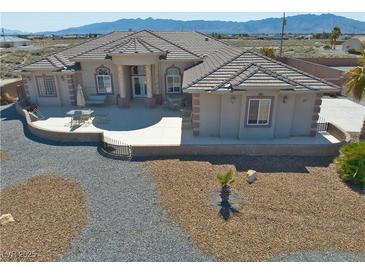 Inviting single-story home showcasing desert landscaping and a covered patio for outdoor relaxation at 961 Laguna St, Pahrump, NV 89048
