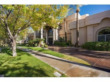 Elegant home exterior featuring lush landscaping, mature trees, and a circular driveway at 1008 Trophy Hills Dr, Las Vegas, NV 89134