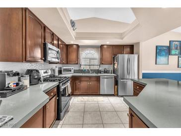 Well-lit kitchen features stainless steel appliances and updated countertops at 10113 Walhalla Plateau Ct, Las Vegas, NV 89148