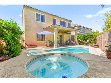 Inviting backyard features a sparkling pool, hot tub, covered patio and lush landscaping perfect for outdoor living at 10823 Drake Ridge Ave, Las Vegas, NV 89166