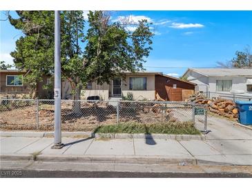Modest single-story home featuring a chain-link fence and mature trees at 121 N 20Th St, Las Vegas, NV 89101