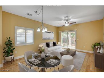 Bright dining area featuring a modern light fixture, round table and view to the living area and backyard at 1435 Orange Jubilee Rd, Henderson, NV 89014