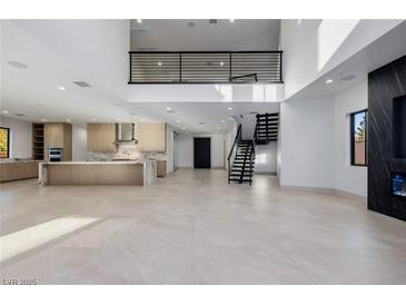 Bright and airy living space featuring an open floor plan, modern staircase, and sleek fireplace at 19 Rue Grimaldi Way, Henderson, NV 89011