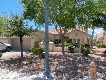 Charming single-story home featuring a tiled roof, two-car garage, and meticulously maintained desert landscaping at 2465 Palmridge Dr, Las Vegas, NV 89134