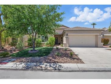 Charming single-story home featuring manicured lawn and a two-car garage, with mature trees providing ample shade at 2579 Ivoryhill St, Las Vegas, NV 89135
