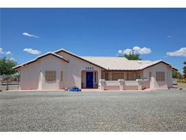 Charming single-story home with desert landscaping, light stucco, and a blue door at 2650 Sagebrush Ave, Pahrump, NV 89048