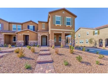 Charming townhome with stone accents, a brick walkway, and desert landscaping at 2887 Starling Summit St, Henderson, NV 89044