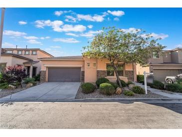 Inviting single-story home featuring a two-car garage, landscaped front yard, and stone accents at 5384 Candlespice Way, Las Vegas, NV 89135