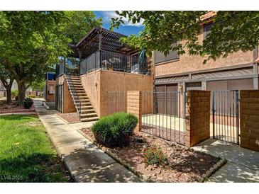 Inviting two-story home with a balcony, private entrance, and fenced front yard with desert landscaping at 6641 Silverstream Ave # C, Las Vegas, NV 89107