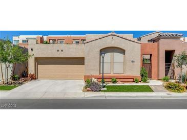 Single-story home showcasing a two-car garage, desert landscaping, and a neutral color palette at 9215 Penn Station St, Las Vegas, NV 89123