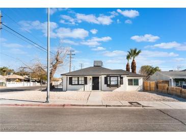 Charming single story home with a gravel yard and palm trees in the front at 1401 E Clark Ave, Las Vegas, NV 89101