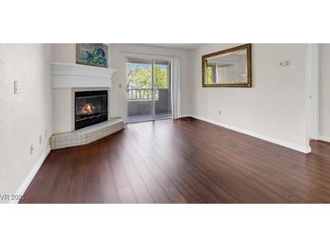 Bright living room features a cozy fireplace, wood flooring, and a sliding door to the outside at 2606 S Durango Dr # 277, Las Vegas, NV 89117