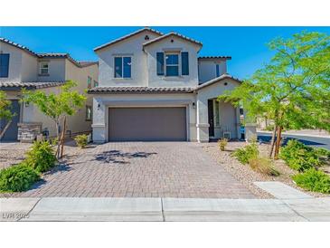 Charming two-story home with a brick driveway and landscaped front yard under a clear sky at 6442 Kobe Knoll Ct, Las Vegas, NV 89141