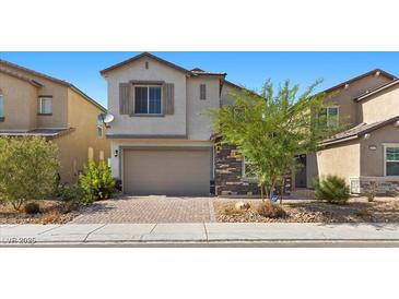 Beautiful two-story home with a brick driveway, tan stucco, stone facade, and a two-car garage at 6854 Chargehand Ave, Las Vegas, NV 89156