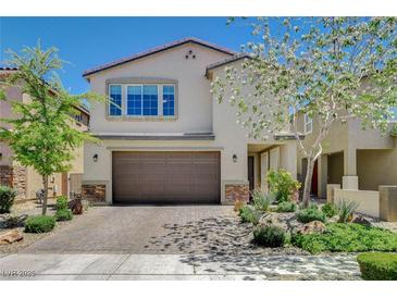 Charming two-story stucco home featuring a brick driveway, desert landscaping, and attached two-car garage at 7246 Dazzle Point St, North Las Vegas, NV 89084