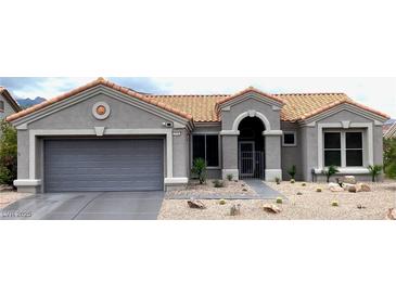 Inviting single-story home with a desert landscape, featuring a terracotta tile roof and gray exterior paint at 2625 Youngdale Dr, Las Vegas, NV 89134