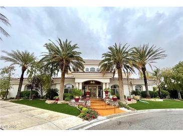 Stunning two-story home featuring lush landscaping, manicured grounds, and a circular driveway lined with mature palm trees at 7625 Coley Ave, Las Vegas, NV 89117