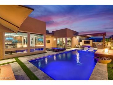 Stunning backyard with a sparkling blue pool, modern pergola, and outdoor seating, perfect for entertaining and relaxation at 819 Bolide St, Las Vegas, NV 89138