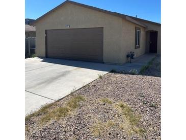 Tan single story house with brown two car garage door and front door at , Las Vegas, NV 89106