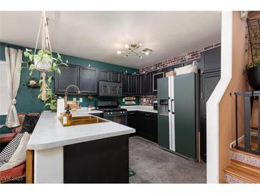 Stylish kitchen features dark cabinetry, modern appliances, and a unique, custom design for a contemporary look at 10403 Fancy Fern St, Las Vegas, NV 89183