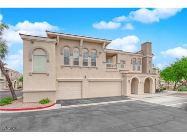 Inviting townhome featuring a two-car garage, charming arches and neutral-toned stucco at 10550 W Alexander Rd # 2233, Las Vegas, NV 89129