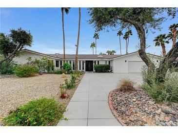 Stunning single-story home featuring mature landscaping, a circular driveway, and a symmetrical facade at 3175 S Torrey Pines Dr, Las Vegas, NV 89146