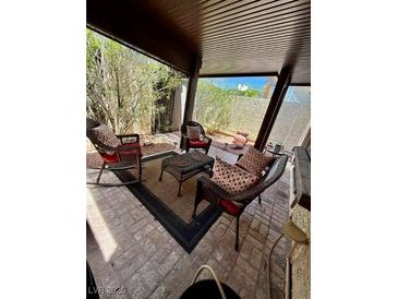 Inviting covered patio featuring wicker furniture and a cozy outdoor seating area at 4662 Kelly Barry Way, Las Vegas, NV 89121