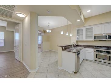 Open kitchen with stainless steel appliances, granite countertops, and bright lighting fixtures at 50 E Serene Ave # 420, Las Vegas, NV 89123