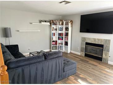 Inviting living room featuring a fireplace, stylish bookshelf, and comfortable seating area at 5024 Starfinder Ave, Las Vegas, NV 89108